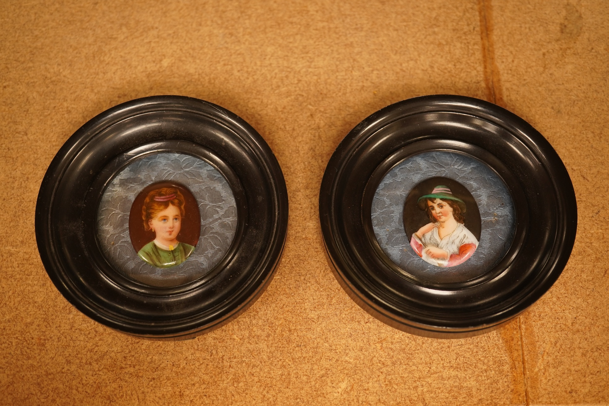 A pair of circular framed oval miniatures on porcelain plaques. Plaques 3.5cm high